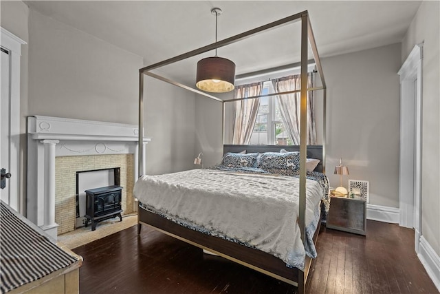 618 Hastings St, Point Breeze, PA 15206 - bedroom with a wood stove, hardwood / wood-style flooring, and baseboards