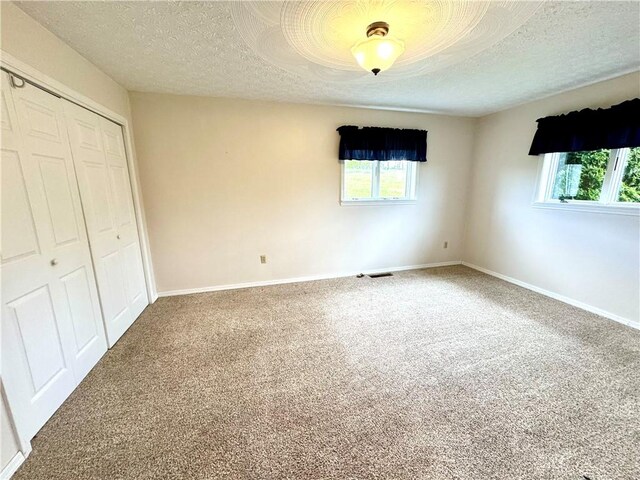 152 Aviator Ln, Somerset Twp, PA 15541 - unfurnished bedroom featuring multiple windows, a closet, carpet, a textured ceiling, and baseboards