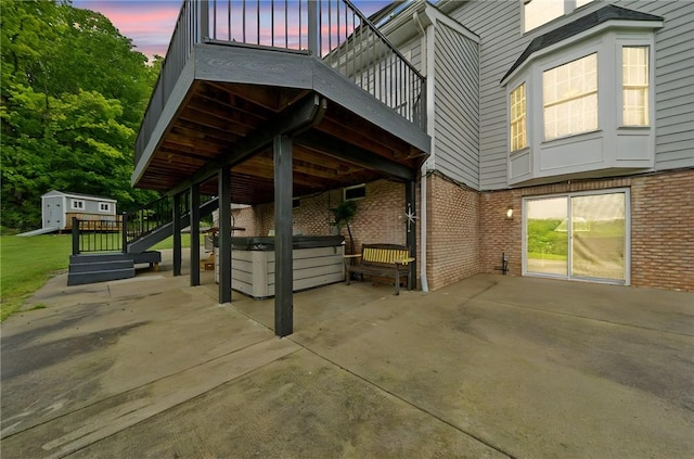 8426 David Dr, South Fayette, PA 15017 - property exterior at dusk featuring a hot tub, a patio area, brick siding, and stairs