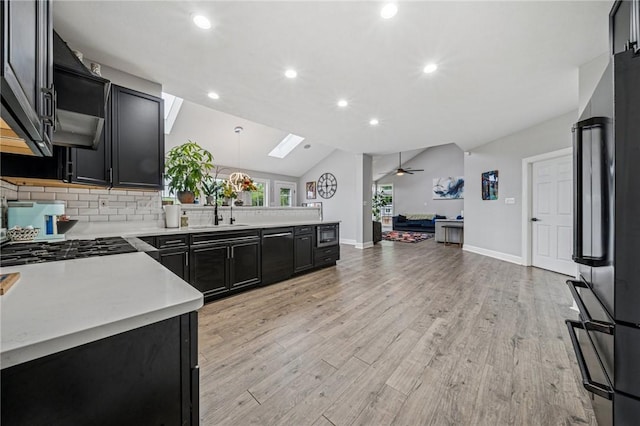 8426 David Dr, South Fayette, PA 15017 - kitchen with dark cabinets, freestanding refrigerator, light countertops, vaulted ceiling, and open floor plan