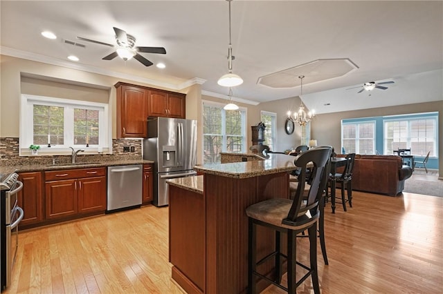 230 Patriot Ln, Economy, PA 15042 - kitchen featuring stainless steel appliances, a ceiling fan, a sink, a breakfast bar area, and light wood-style floors
