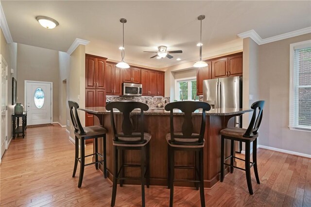 230 Patriot Ln, Economy, PA 15042 - kitchen featuring appliances with stainless steel finishes, backsplash, ceiling fan, light wood-type flooring, and a center island