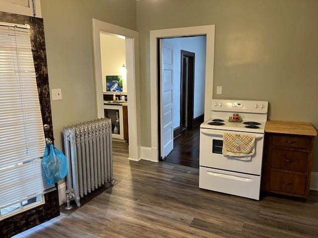 201 Thompson St, Latrobe, PA 15650 - kitchen featuring white range with electric cooktop, radiator, dark wood-style floors, light countertops, and baseboards