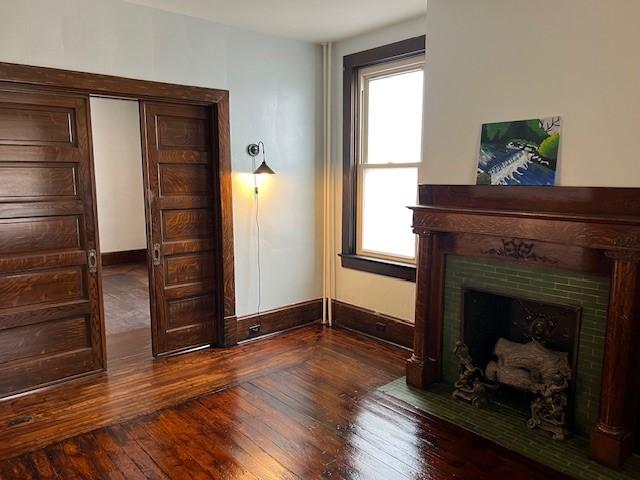 201 Thompson St, Latrobe, PA 15650 - unfurnished living room with wood-type flooring, baseboards, and a fireplace with flush hearth