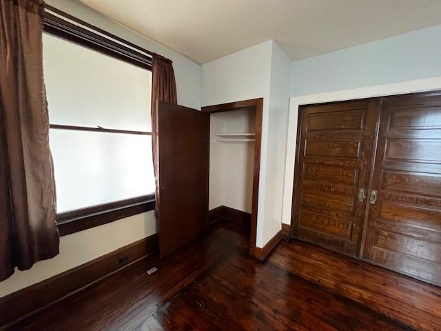 201 Thompson St, Latrobe, PA 15650 - unfurnished bedroom with dark wood-style floors, a closet, and baseboards