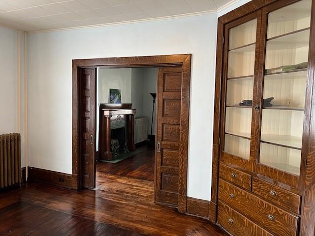 201 Thompson St, Latrobe, PA 15650 - corridor featuring radiator, radiator heating unit, wood finished floors, ornamental molding, and baseboards