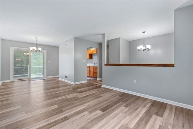 916 Timberland Ave, Brookline, PA 15226 - unfurnished living room with a chandelier, baseboards, light wood-type flooring, and a sink