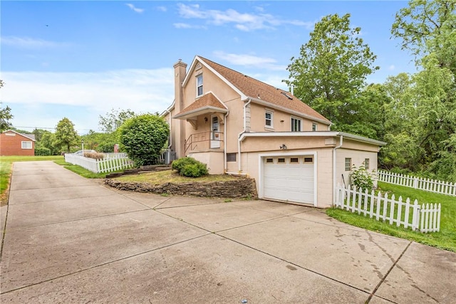 2400 James St, Hopewell Twp Bea, PA 15001 - view of front of home with driveway, stucco siding, a chimney, a garage, and central AC