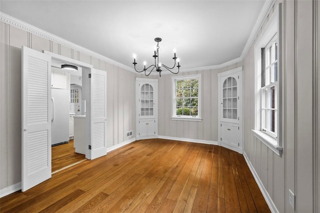 1509 Walnut St, Edgewood, PA 15218 - unfurnished dining area with a chandelier, light wood-style floors, ornamental molding, and baseboards