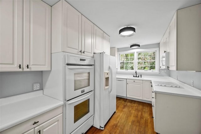 1509 Walnut St, Edgewood, PA 15218 - kitchen featuring white appliances, a sink, white cabinetry, dark wood finished floors, and light countertops