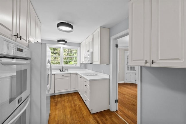 1509 Walnut St, Edgewood, PA 15218 - kitchen featuring white appliances, wood finished floors, and white cabinets