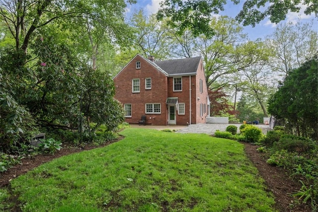 1509 Walnut St, Edgewood, PA 15218 - back of property featuring a patio area, a lawn, a chimney, and brick siding