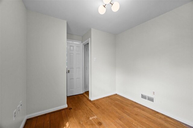 1509 Walnut St, Edgewood, PA 15218 - unfurnished room with baseboards, light wood-type flooring, and a chandelier