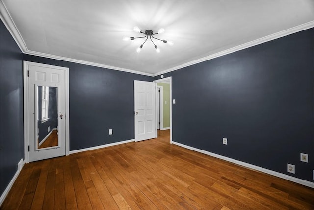 1509 Walnut St, Edgewood, PA 15218 - spare room with a chandelier, wood-type flooring, baseboards, and crown molding