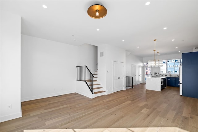 244 44th St, Lawrenceville, PA 15201 - kitchen featuring open floor plan, light countertops, light wood-style floors, recessed lighting, and a center island
