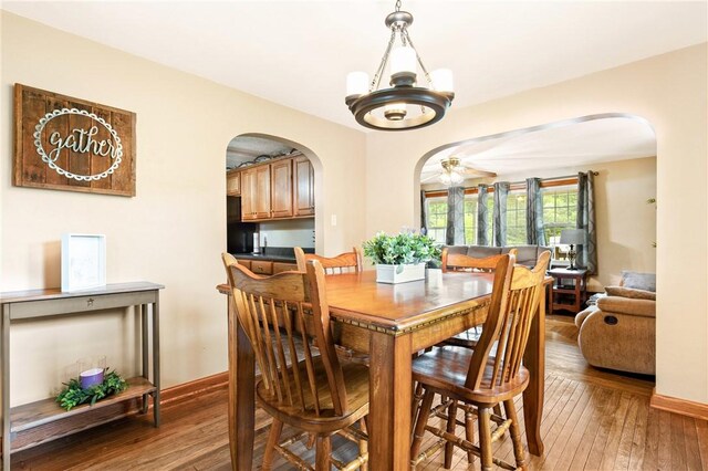 4624 Clear Shade Dr, Windber, PA 15963 - dining room featuring arched walkways, wood-type flooring, baseboards, and a chandelier