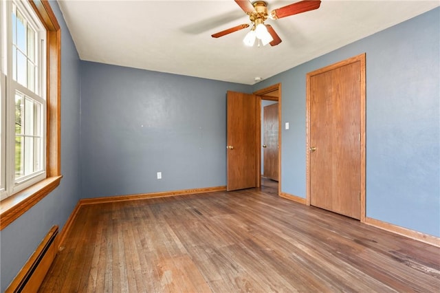 4624 Clear Shade Dr, Windber, PA 15963 - unfurnished bedroom featuring baseboard heating, hardwood / wood-style floors, and baseboards