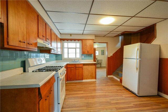 61/63 Orchard, Mckees Rocks, PA 15136 - kitchen featuring white appliances, under cabinet range hood, light wood-style flooring, brown cabinets, and a drop ceiling