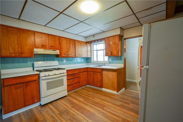 61/63 Orchard, Mckees Rocks, PA 15136 - kitchen with white appliances, a paneled ceiling, under cabinet range hood, brown cabinets, and light wood-style flooring