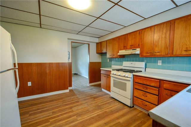 61/63 Orchard, Mckees Rocks, PA 15136 - kitchen featuring white appliances, under cabinet range hood, a drop ceiling, a wainscoted wall, and brown cabinetry