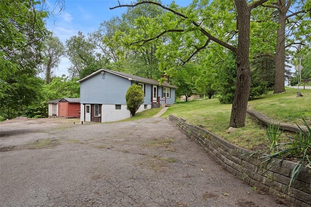 724 Camp Meeting Rd, Bell Acres, PA 15143 - view of front facade with asphalt driveway, a front yard, a chimney, and a storage shed