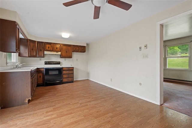 724 Camp Meeting Rd, Bell Acres, PA 15143 - kitchen featuring black range with electric stovetop, under cabinet range hood, light wood-style floors, light countertops, and a baseboard heating unit