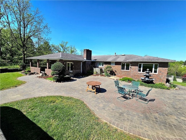2977 Clay Pike, Sewickley Twp, PA 15678 - rear view of property featuring a patio area, a chimney, and brick siding