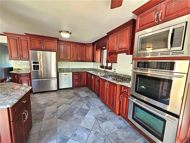 2977 Clay Pike, Sewickley Twp, PA 15678 - kitchen featuring appliances with stainless steel finishes, dark brown cabinets, dark stone finish floors, and a sink