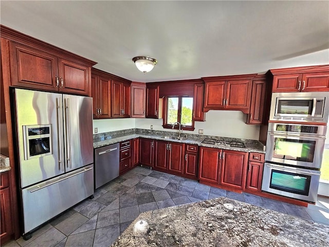 2977 Clay Pike, Sewickley Twp, PA 15678 - kitchen with stainless steel appliances, dark brown cabinets, dark stone counters, a sink, and dark stone finish flooring
