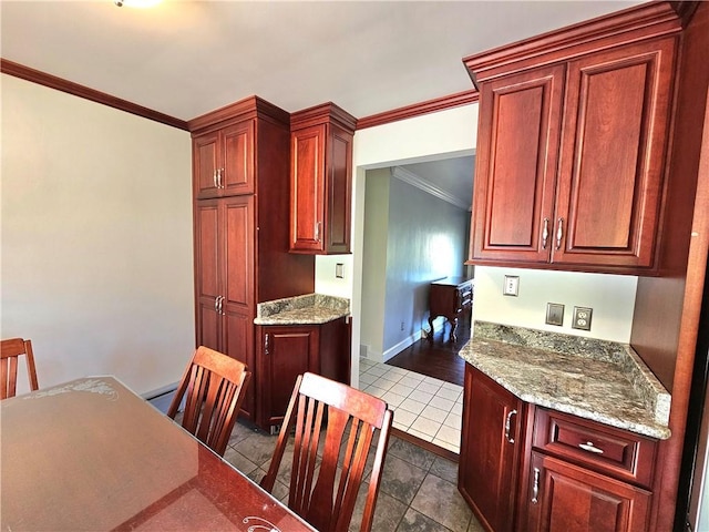 2977 Clay Pike, Sewickley Twp, PA 15678 - kitchen with crown molding, dark tile patterned floors, reddish brown cabinets, baseboards, and light stone countertops