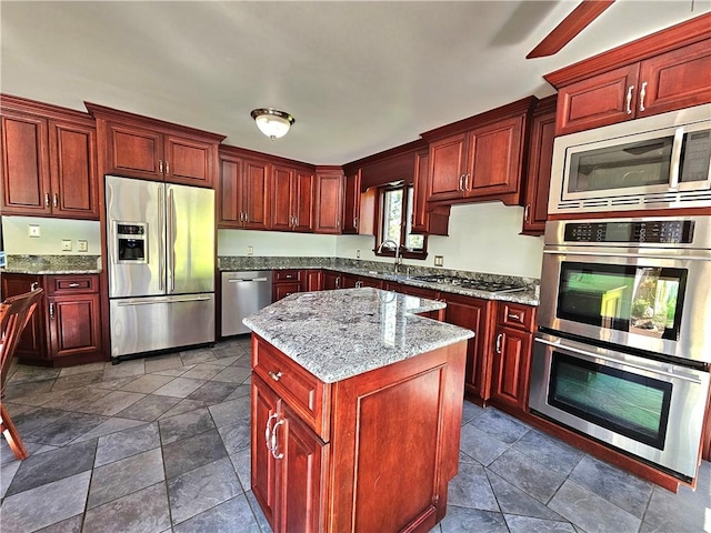 2977 Clay Pike, Sewickley Twp, PA 15678 - kitchen with appliances with stainless steel finishes, reddish brown cabinets, a sink, and a kitchen island