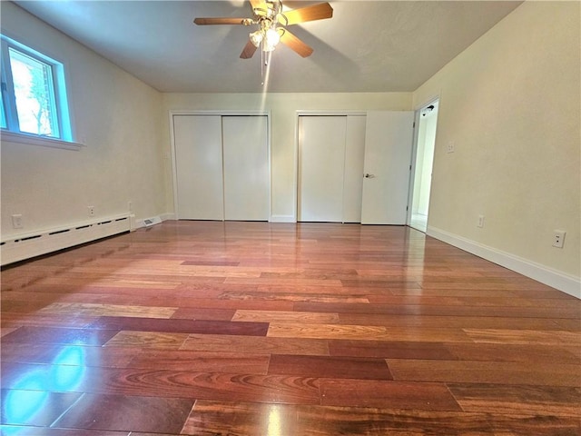 2977 Clay Pike, Sewickley Twp, PA 15678 - unfurnished bedroom with a baseboard heating unit, wood finished floors, multiple closets, baseboards, and a ceiling fan