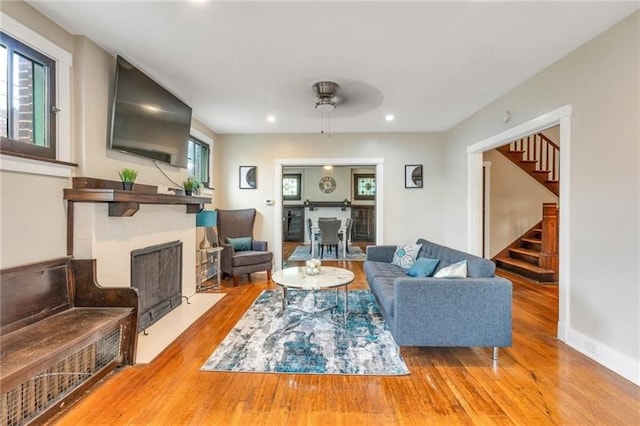 901 Ross Ave, Wilkinsburg, PA 15221 - living room with a fireplace with flush hearth, stairs, wood finished floors, recessed lighting, and a ceiling fan
