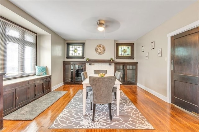 901 Ross Ave, Wilkinsburg, PA 15221 - dining space with a ceiling fan, a brick fireplace, baseboards, and light wood-type flooring