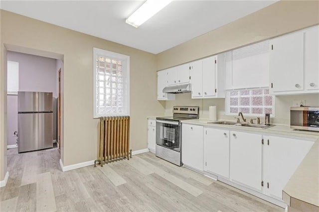 901 Ross Ave, Wilkinsburg, PA 15221 - kitchen with radiator heating unit, stainless steel appliances, a sink, under cabinet range hood, and light wood-style flooring