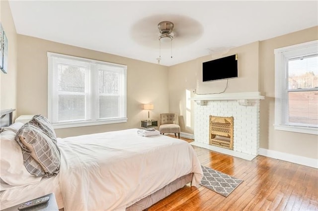 901 Ross Ave, Wilkinsburg, PA 15221 - bedroom with hardwood / wood-style flooring, baseboards, a fireplace, and a ceiling fan
