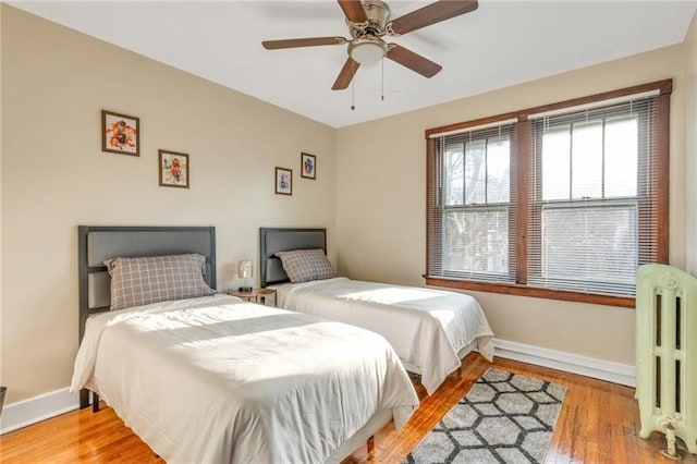 901 Ross Ave, Wilkinsburg, PA 15221 - bedroom featuring radiator, baseboards, wood finished floors, and a ceiling fan