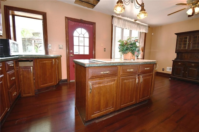 108 Locust St, Mount Oliver, PA 15210 - kitchen with dark wood finished floors, ceiling fan, brown cabinets, a kitchen island, and baseboards