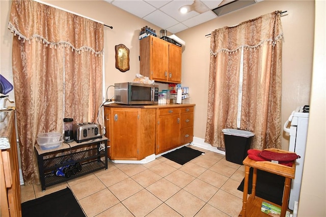 108 Locust St, Mount Oliver, PA 15210 - kitchen featuring stainless steel microwave, brown cabinets, light tile patterned flooring, and light countertops