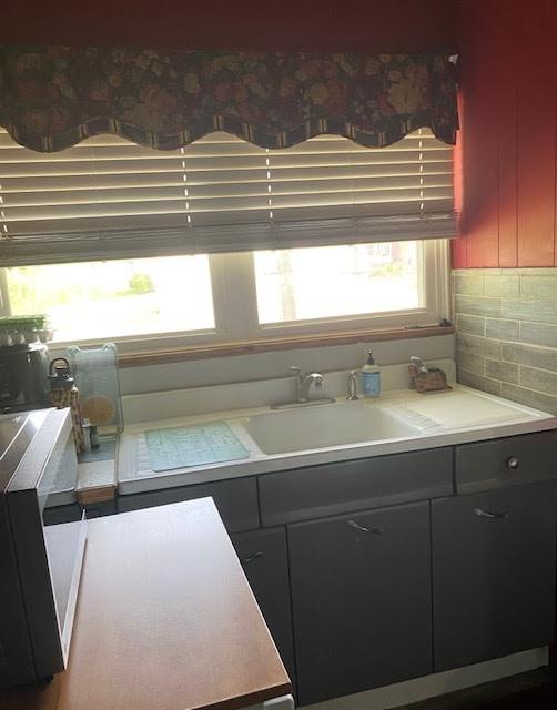 10672 Center Ave, Conneaut Lake, PA 16316 - kitchen featuring a sink and decorative backsplash
