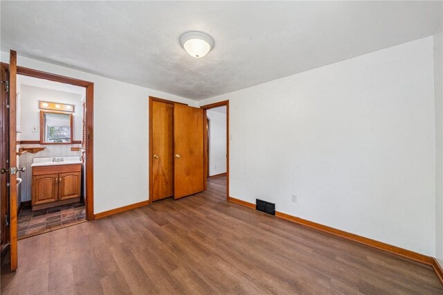 134 Hamilton Dr, Penn Hills, PA 15235 - unfurnished bedroom with wood finished floors, baseboards, a closet, and ensuite bathroom