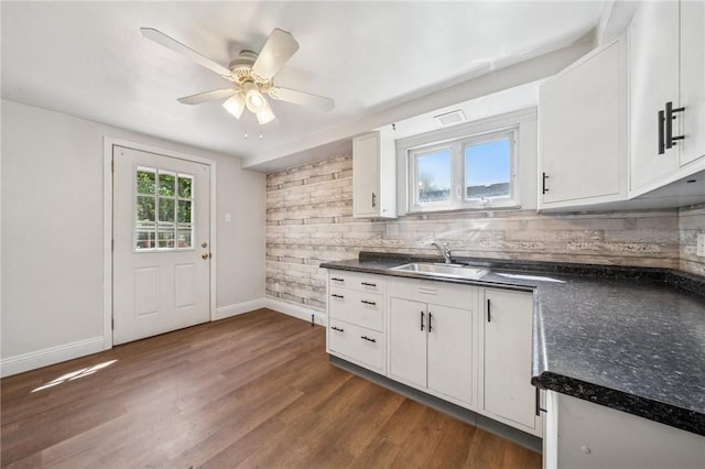 134 Hamilton Dr, Penn Hills, PA 15235 - kitchen with a sink, dark countertops, decorative backsplash, and white cabinetry