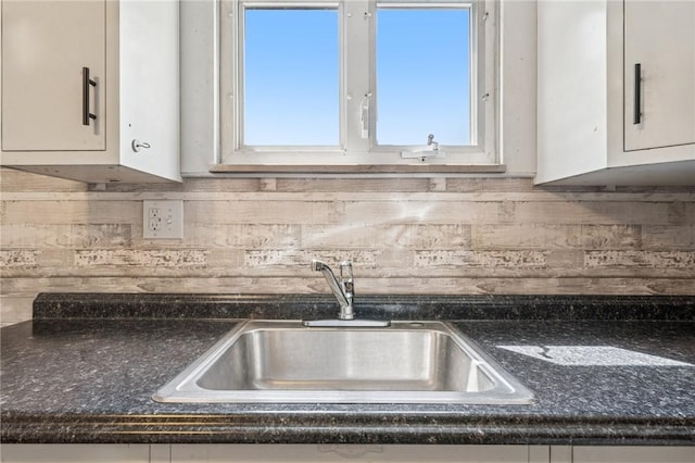 134 Hamilton Dr, Penn Hills, PA 15235 - kitchen featuring a sink, decorative backsplash, white cabinetry, and dark countertops