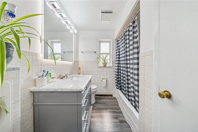 3003 Jersey St, Mckeesport, PA 15132 - full bath with vanity, toilet, tile walls, wood finished floors, and healthy amount of natural light