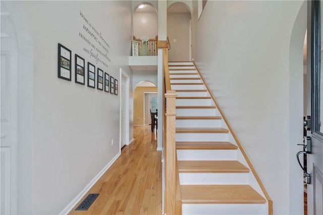 205 Emily Dr, Cranberry Twp, PA 16066 - staircase with arched walkways, wood finished floors, baseboards, and a towering ceiling