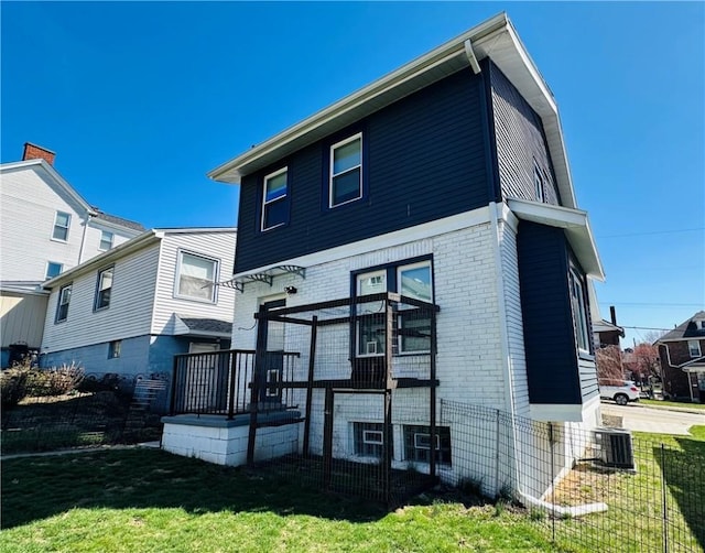 62 Laurel Ave, City Of Washington, PA 15301 - back of house with brick siding, a lawn, and central AC unit