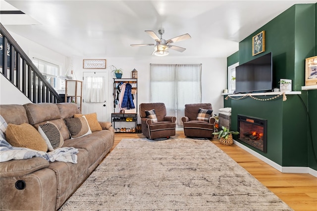 62 Laurel Ave, City Of Washington, PA 15301 - living area featuring stairway, wood finished floors, a ceiling fan, and a glass covered fireplace