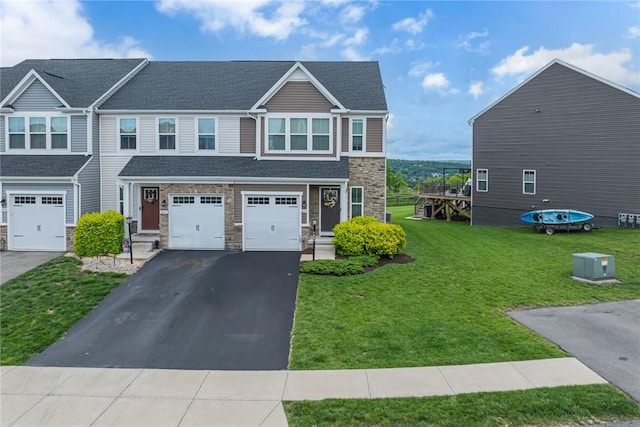 2054 Cade Dr, Potter Twp, PA 15061 - view of front of house with stone siding, asphalt driveway, an attached garage, a front yard, and a shingled roof