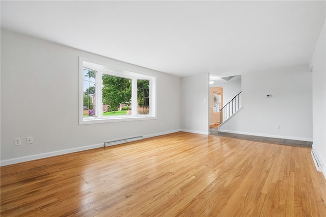 7965 Remington Dr, Mccandless, PA 15237 - empty room featuring baseboard heating, stairway, light wood finished floors, and baseboards