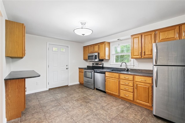 7965 Remington Dr, Mccandless, PA 15237 - kitchen featuring appliances with stainless steel finishes, a sink, dark countertops, brown cabinetry, and baseboards